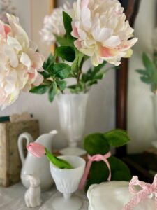 a milk glass vase with extra large faux peonies on a mantel for spring decor