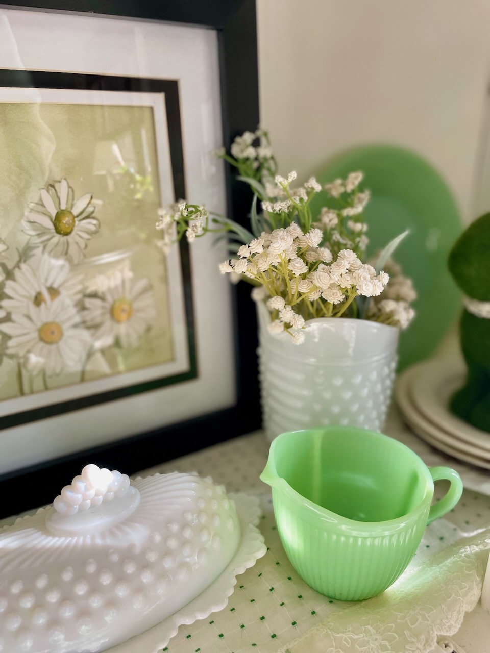 vintage hutch styled for spring with green transferware, jadeite, ironstone, and faux florals