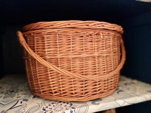 a thrifted lidded basket used for storage in a bathroom