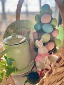 Simple spring vignette on a credenza with vintage milk glass, ironstone, and a seasonal basket