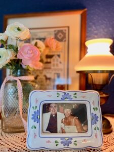 top of an antique curio cabinet displayed with thrifted finds and heirloom photos