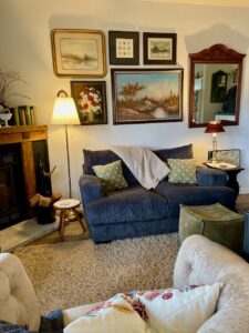 full room view of a living room decorated with secondhand and thrift store furniture and decor