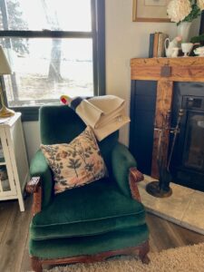 Antique green chair in a living room furnished almost entirely from thrift stores and antique malls