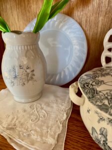 vintage handkerchiefs and blue and white transferware styled inside an antique curio cabinet for spring