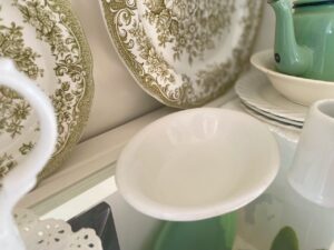 A collection of thrifted ironstone pieces arranged on a shelf