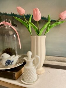 Doily layered under a vintage vignette on a bathroom shelf