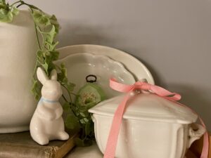 Vintage creamers and lidded dishes grouped in a styled bathroom vignette 
