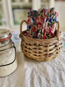 thrifted cloth napkins rolled and tucked into a vintage basket as a table vignette