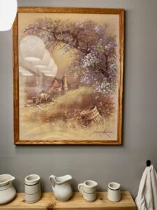 Collected and curated vintage bathroom styled with thrifted art, linens, and ironstone