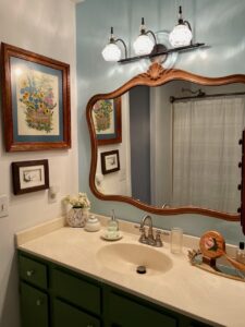 Vintage art framed and hung on a bathroom wall as an anchor piece