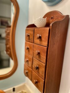 Close-up detail of vintage spice cabinet drawers used for bathroom organization