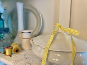 Ironstone tureens layered into a cottage-style summer hutch display