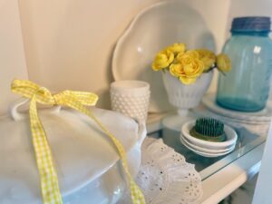 layering in vintage decor in a hutch display for summer