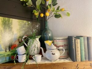 Thrifted summer mantel decor featuring chippy vintage enamelware in a farmhouse style