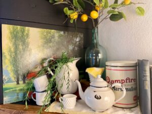Vintage marshmallow tin tucked into a summer mantel display with enamelware