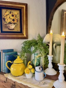 Summer mantel vignette with vintage enamelware, milk glass, and old books
