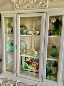 full summer hutch display with vintage and thrifted pieces for a cottage garden feeling