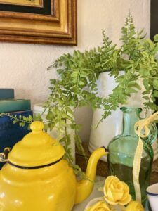 Close-up detail of vintage enamelware and milk glass on a styled summer mantel