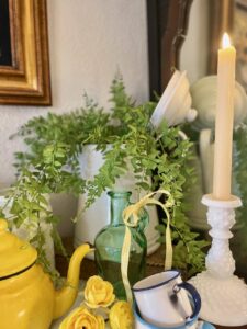 Thrifted vintage enamelware pitcher styled on a summer mantel with faux ferns
