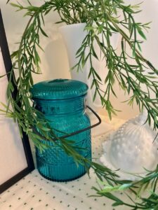 trailing greenery draped over a vintage hutch shelf for summer decorating