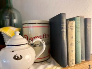 Layered vintage books on a summer mantel paired with blue and white enamelware