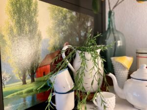 Vintage enamelware pitcher used as a focal point in a blue and white summer mantel