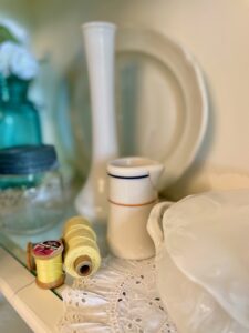 vintage sewing notions and other small accessories styled in a summer hutch display