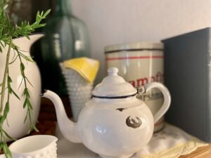 Vintage enamelware summer mantel decor styled with blue, white, and yellow thrifted pieces
