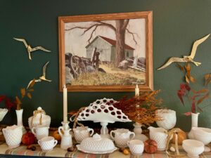 vintage thrifted brass birds styled on a wall against a milk glass vignette for fall