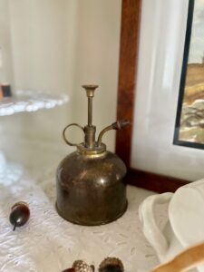 vintage brass plant mister styled in a hutch for fall