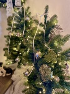 champagne bows tied onto Christmas trees as tree toppers